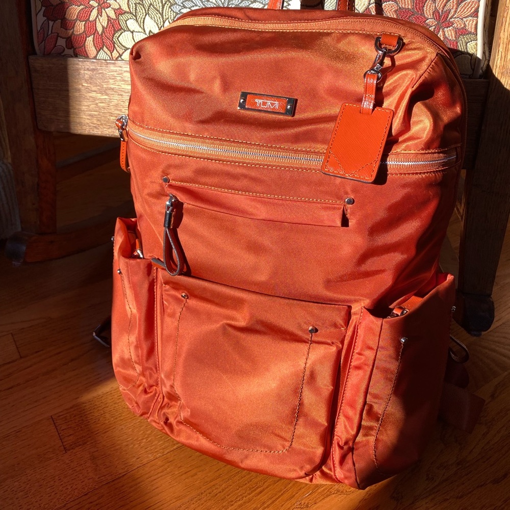 TUMI backpack. Perfect for a carryon, beautiful burnt orange. Perfect condition!